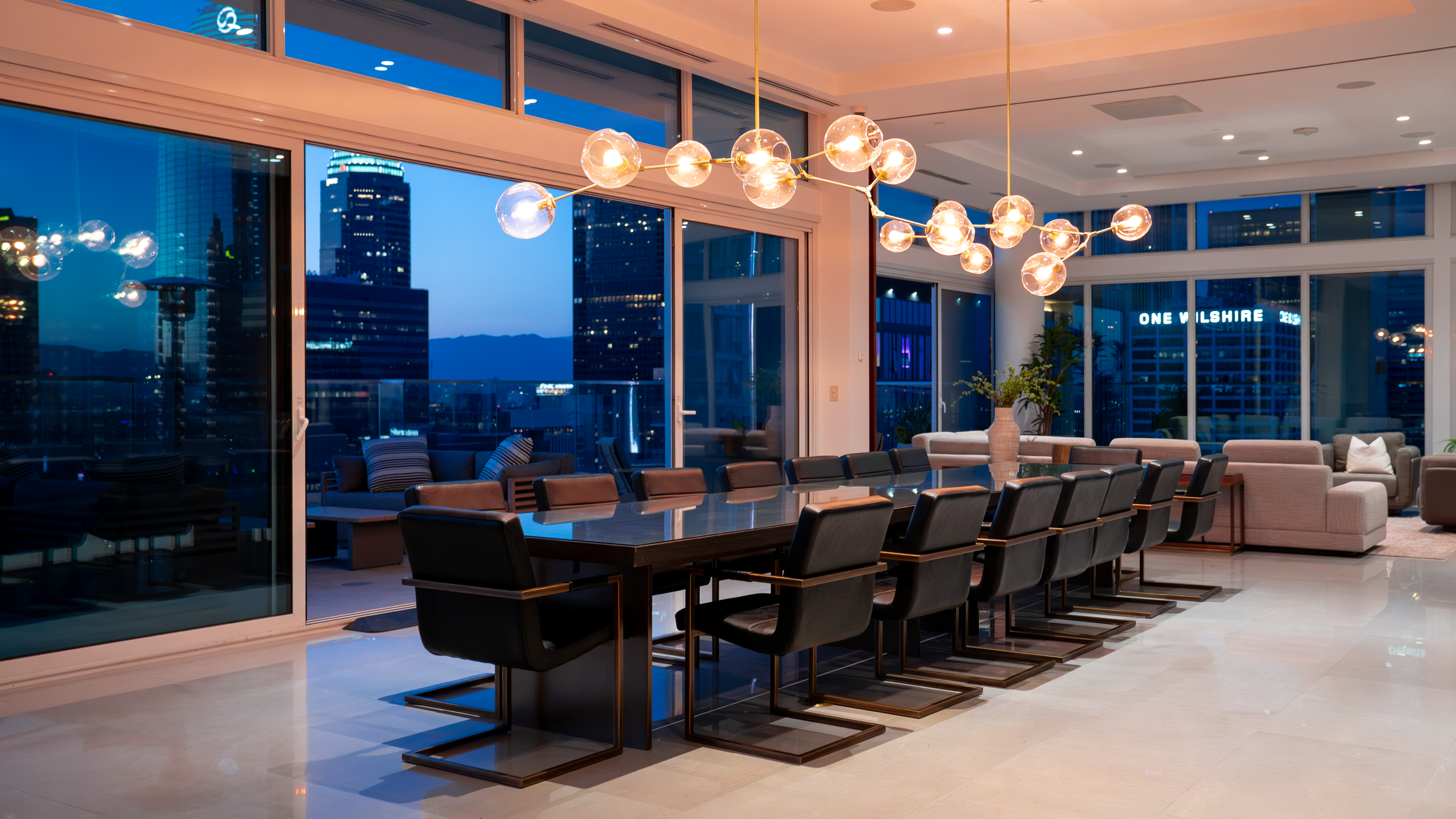 888 S. Olive dining table at night with One Wilshire lit up beyond
